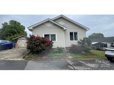 Cozy home featuring light siding, well-maintained landscaping, and double-hung windows at 380 Woodlawn Ave, Cramerton, NC 28032