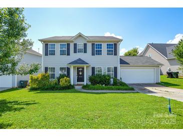 Charming two-story home with a well-manicured lawn, lush landscaping, and an attached two-car garage at 4075 Clover Nw Rd, Concord, NC 28027