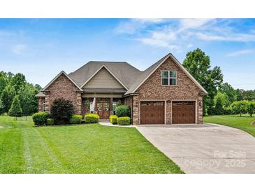 Beautiful brick home featuring a two-car garage, manicured lawn, and charming front yard landscaping at 5163 Meadow Park Ln, Hickory, NC 28602