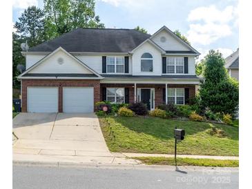 Charming two-story home featuring a well-manicured lawn, two-car garage, and brick and white siding at 5227 Eagle Creek Dr, Charlotte, NC 28269
