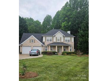 Charming two-story brick home with a well-manicured lawn and attached two-car garage at 5625 Linda Vista Ln, Charlotte, NC 28216