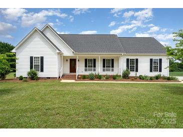 Charming single-story home featuring a covered front porch, manicured lawn, and classic architectural details at 6201 New Hope Church Rd, Marshville, NC 28103