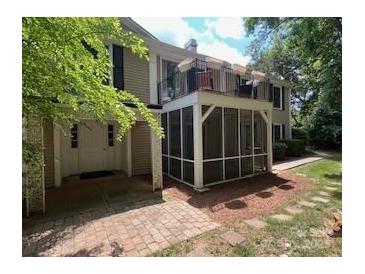 Charming townhouse featuring a screened porch and second-story balcony, surrounded by mature trees at 7026 Quail Hill Rd, Charlotte, NC 28210