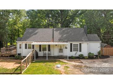 Charming one-story home with a landscaped front yard, a porch swing, and a fenced yard at 800 Woodlawn St, Belmont, NC 28012