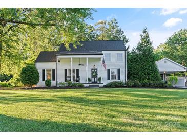 Charming white two-story home with rocking chair front porch and an American flag at 1020 12Th Nw Ave, Hickory, NC 28601