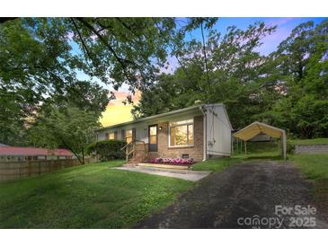 Charming home with well-maintained lawn and flowering garden beds leading to a covered carport at 1075 Parkview Dr, Gastonia, NC 28054