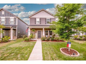 Charming two-story home with landscaped yard and inviting front porch in a suburban neighborhood at 11951 Old Statesville Rd, Huntersville, NC 28078