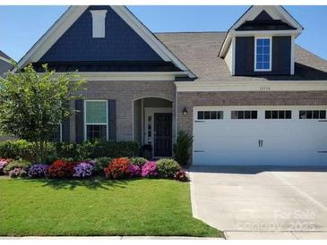 Charming home featuring a brick facade, well-manicured lawn, and a welcoming front porch at 13338 Blanton Dr, Huntersville, NC 28078