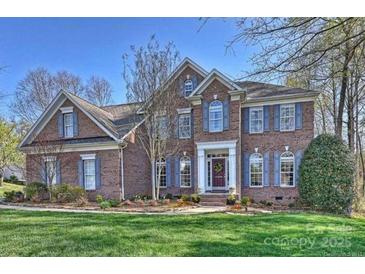 Charming two-story brick home with a manicured lawn and inviting front entrance at 15494 Donnington Dr, Charlotte, NC 28277