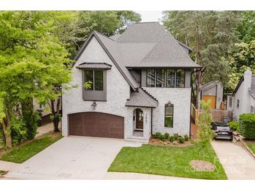 Charming two-story painted brick home with a well-manicured lawn and a stylish brown garage door at 1625 Club Rd, Charlotte, NC 28205