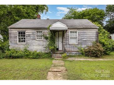 Exterior of a one story home needing renovation and new landscaping at 2308 Vanderbilt Rd, Charlotte, NC 28206