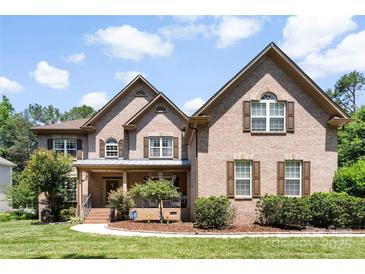 Charming brick home featuring a manicured lawn and inviting front porch at 6300 Latta Springs Cir, Huntersville, NC 28078