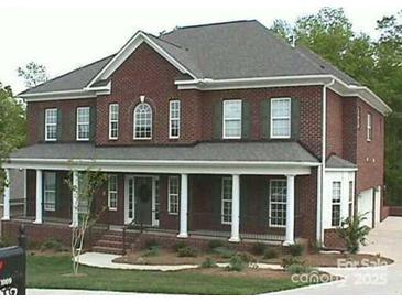Traditional brick two-story home featuring a welcoming front porch with white columns and a well-manicured lawn at 1009 Brookline Dr, Huntersville, NC 28078