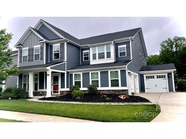 Two-story home with blue siding, white trim, attached two car garage, and a manicured front yard at 10112 Andres Duany Dr, Huntersville, NC 28078