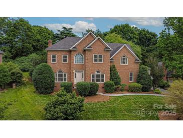 Elegant brick two-story home with arched windows and manicured landscaping on a lush, green lawn at 103 Samuel Guilford Ct, Charlotte, NC 28270