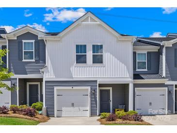 Charming townhome featuring a one car garage and landscaped front yard, perfect for a modern living experience at 1563 Old Rivers Rd, Concord, NC 28027