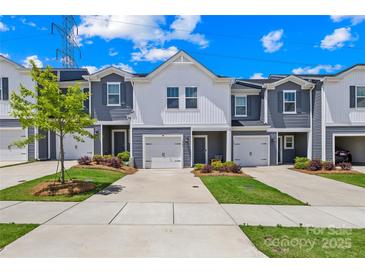 Charming townhome with a garage and a well-manicured front yard at 1563 Old Rivers Rd, Concord, NC 28027