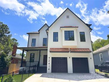 Charming two-story home with a white brick facade, dark trim, and a two-car garage at 2414 E 7Th St, Charlotte, NC 28204