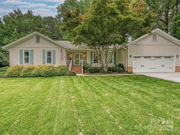 Charming single-story home with well-manicured lawn, attached garage, and mature landscaping at 2911 Butter Churn Ln, Matthews, NC 28105