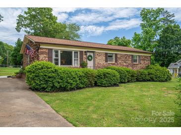 Charming brick home with a well-manicured lawn and lush landscaping, creating an inviting curb appeal at 3424 Autumn Dr, Gastonia, NC 28056