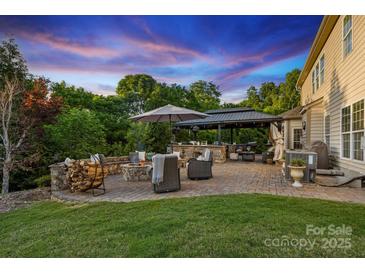 Outdoor patio area featuring a fire pit, outdoor grill, and ample seating for entertaining guests at 4430 Bravery Sw Pl, Concord, NC 28027
