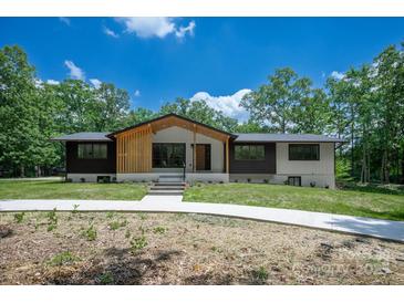 Inviting exterior showcasing a charming two-tone facade and well-maintained lawn at 5033 Waxhaw Indian Trail Rd, Matthews, NC 28104