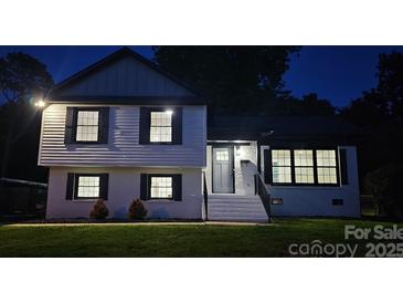 Charming two-story home with well-lit windows and a neatly landscaped front yard at twilight at 6328 Beecher Dr, Charlotte, NC 28215