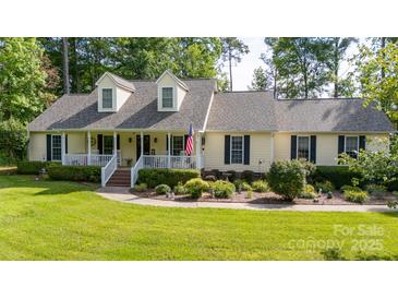 Charming home featuring a welcoming front porch, dormer windows, lush landscaping, and a well-maintained lawn at 785 Sanside Dr, York, SC 29745