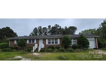 Charming brick home featuring a well-maintained lawn and mature trees in a quiet neighborhood at 116 E Graves St, Candor, NC 27229