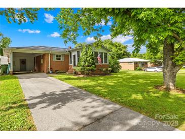 Charming brick home with a well-manicured lawn, mature trees, and a long driveway, offering a welcoming curb appeal at 119 Oak Ave, Shelby, NC 28152
