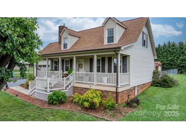 Charming home featuring a welcoming front porch, manicured landscaping, and classic architectural details at 139 Pleasant Garden Dr, Taylorsville, NC 28681