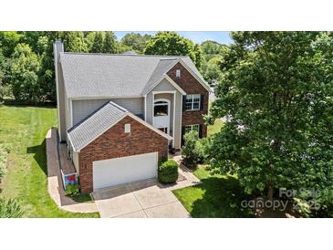Charming two-story home with brick and siding exterior, attached garage, and mature landscaping at 16018 Hollingbourne Rd, Huntersville, NC 28078