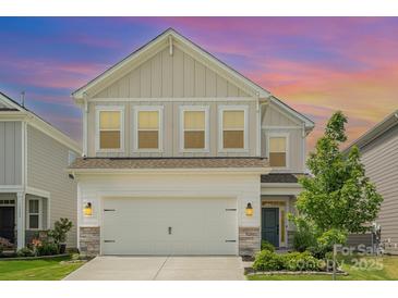 Charming two-story home with neutral siding, manicured lawn, and inviting curb appeal at sunset at 16018 River Tree Ln, Charlotte, NC 28278