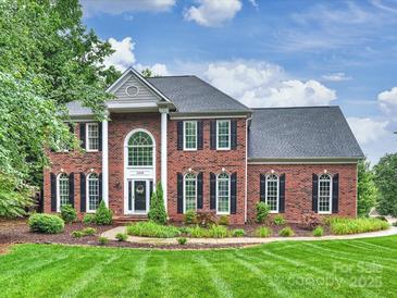 Stately brick home with lush landscaping, dark shutters, and manicured lawn at 16308 Woolwine Rd, Charlotte, NC 28278