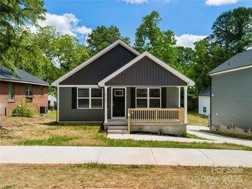 Charming newly built one-story home with gray siding, a front porch and mature trees at 212 N Correll St, Landis, NC 28025
