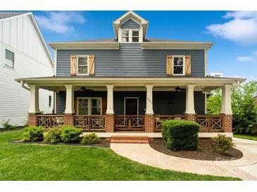 Charming two-story home featuring a welcoming front porch with stylish wood and brick accents at 2217 Yadkin Ave, Charlotte, NC 28205