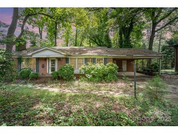Charming single-story brick home with a covered carport and mature landscaping at 3526 Craig Ave, Charlotte, NC 28211