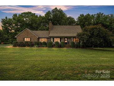 Charming brick home featuring manicured lawn, lush landscaping and mature trees at 3998 Holly Springs Dr # 20, Newton, NC 28658