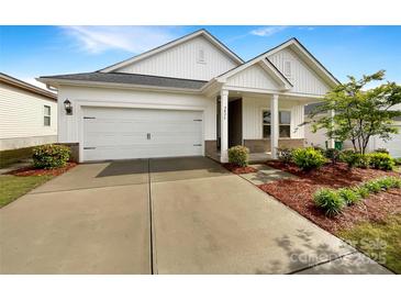 Charming home featuring a two-car garage and a welcoming front porch, complemented by fresh landscaping at 4026 Honey Locust Dr, Charlotte, NC 28215