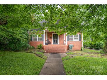 Charming brick home with a cozy front porch and well-maintained lawn at 411 Hanna St, Gastonia, NC 28052