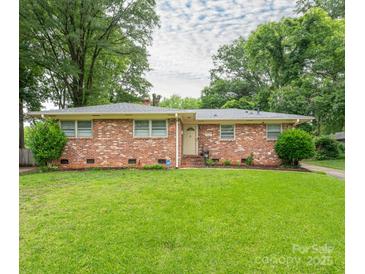 Charming single-story brick home featuring a lush green lawn and mature trees at 5629 Ruth Dr, Charlotte, NC 28215