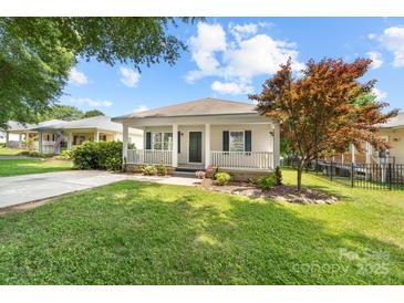 Charming single-story home featuring a welcoming front porch, landscaped yard, and a freshly paved driveway at 613 Church St, Belmont, NC 28012