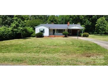 Charming single-story home with a well-manicured lawn and mature trees at 8000 Chapman St, Charlotte, NC 28216