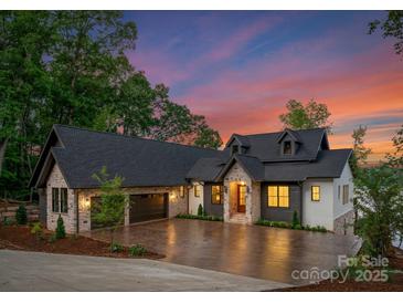 Stunning home showcasing stone and siding, a well-manicured lawn, and a spacious driveway leading to a two-car garage at 8066 Edgewater Dr # 103, Norwood, NC 28128