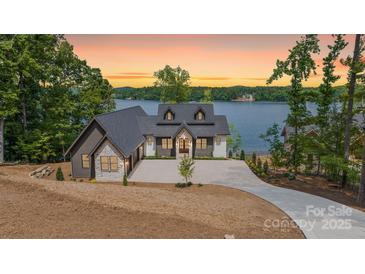 Stunning lakefront home with a modern design and stone accents with breathtaking sunset views at 8066 Edgewater Dr # 103, Norwood, NC 28128