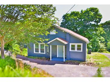 Charming blue home featuring a quaint entryway and surrounded by lush greenery and shade trees at 102 Lake Dr, Hickory, NC 28601