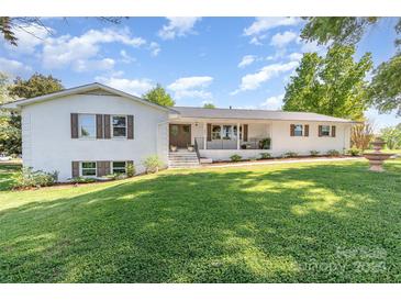 Charming white brick home featuring lush front yard and a cozy front porch at 1041 Brawley School Rd, Mooresville, NC 28117