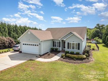 Charming single story home with well manicured lawn, attached garage, and driveway at 115 Meadow Lake Dr, Salisbury, NC 28146