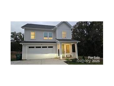 Charming two-story home features a white exterior, attached garage, and well-maintained landscaping at 320 Lawrence Gray Rd, Charlotte, NC 28262