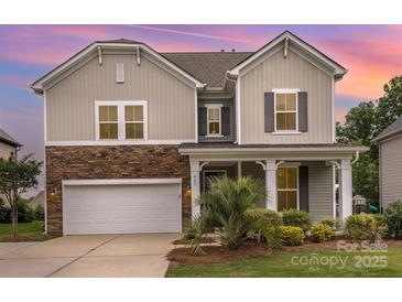 Charming two-story home with stone accents, lush landscaping, and an attached two-car garage at 463 Hunton Forest Nw Dr, Concord, NC 28027